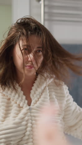 attractive lady rubs hair with nourishing oil in bathroom. woman does care treatments for scalp with shiny hair in bright bathroom slow motion