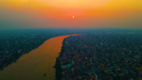 aerial view of dhaka city with buriganga river at sunset in bangladesh. establishing shot