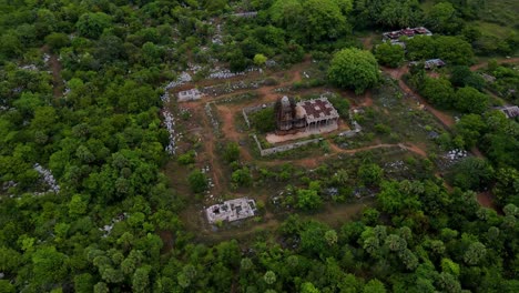 aerial drone shot over vizag, revealing the dense, lush green forest along the mountainside, with the ocean on the horizon.
