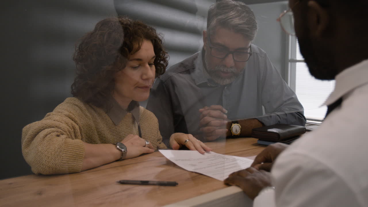 Couple Signing Documents With Doctor