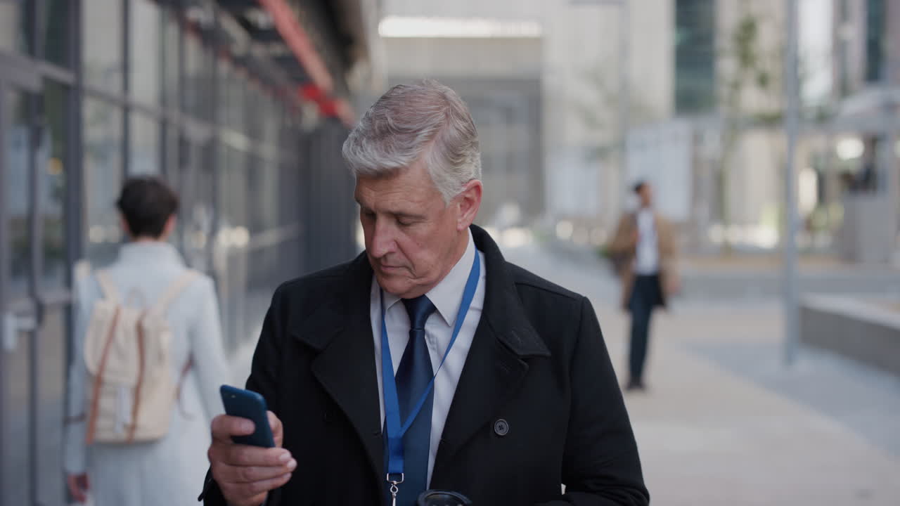 portrait professional senior businessman using smartphone in city checking messages texting on mobile phone drinking coffee enjoying relaxed urban lifestyle slow motion