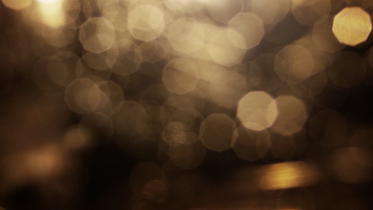 Luci bokeh dorate astratte scintillanti su sfondo scuro