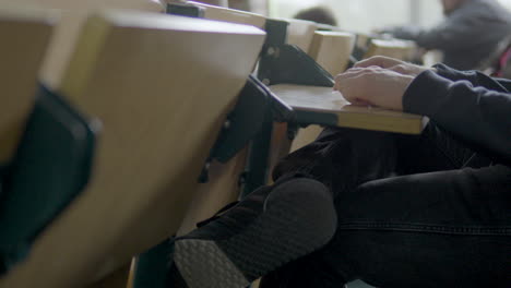 estudiante caucásico sentado en el escritorio atento en el aula, de cerca