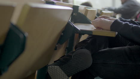 caucasian student sitting on desk attentive in classroom,close up