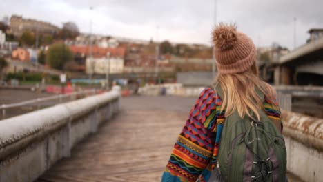 lady in colourful clothing crossing a bridge in bristol uk