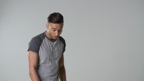 young man in t-shirt looking up to camera, waist up