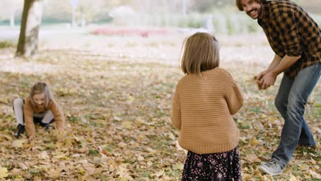 Handheld-Ansicht-Einer-Familie,-Die-Spaß-Mit-Herbstlichen-Blättern-Hat