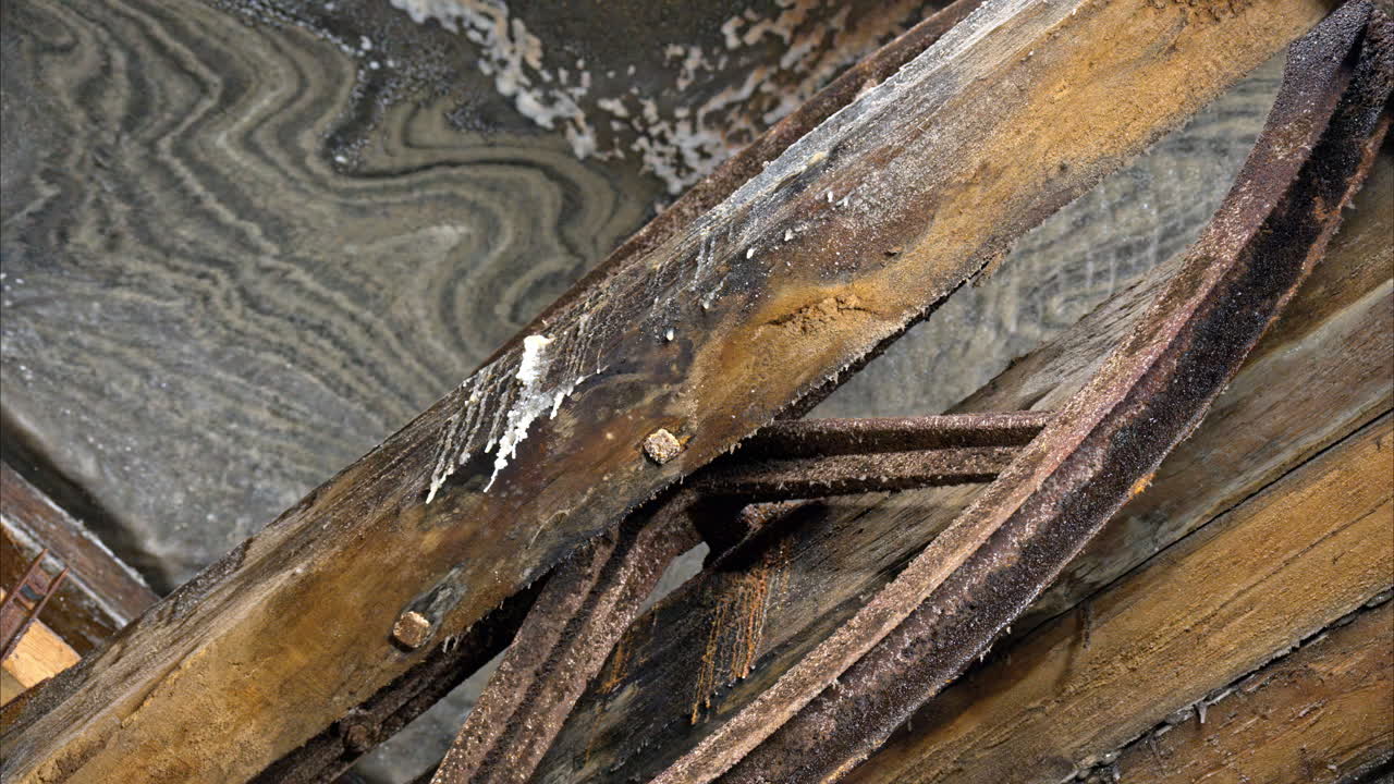 A historic wooden lift system and rusty machinery inside of the Turda Salt Mine in Romania