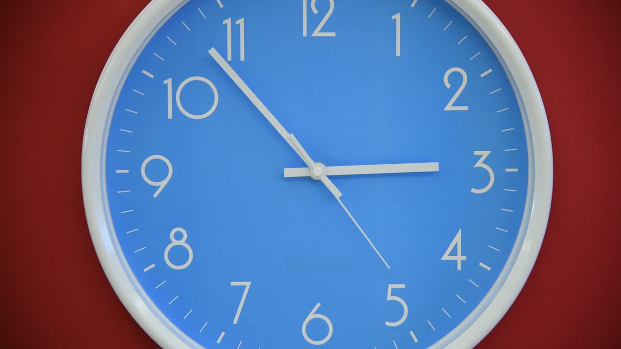 Blue wall clock on red background | Premium Stock Video Footage