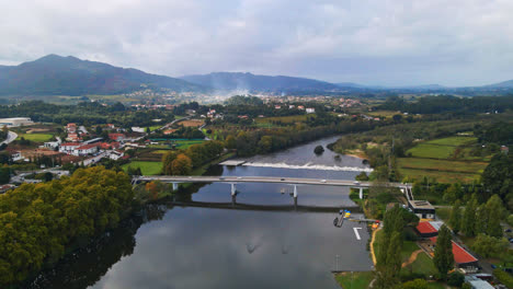 Stunning-aerial-4K-drone-footage-of-a-village---Ponte-de-Lima-in-Portugal-and-its-iconic-landmark---Stone-roman-bridge-crossing-over-the-Lima-River