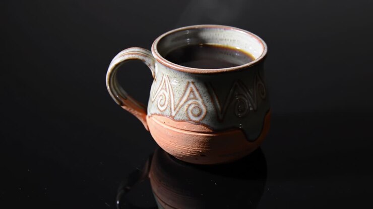 A Beautifully Crafted Ceramic Coffee Mug Reflecting Light, Capturing the Rich Aroma of Brewed Coffee with a Mesmerizing Steam Rising from its Surface