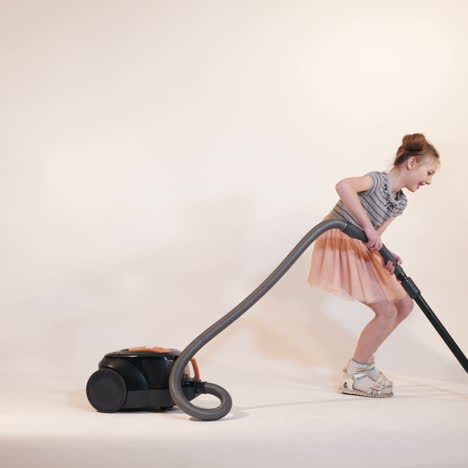Little children play with a vacuum cleaner. Emotions of the child. Studio shooting of children.