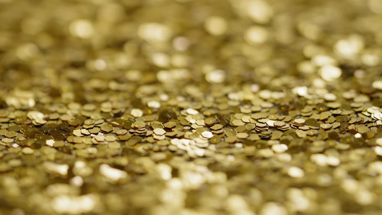 Slow pan across bright gold sequins and glitter, macro shallow focus