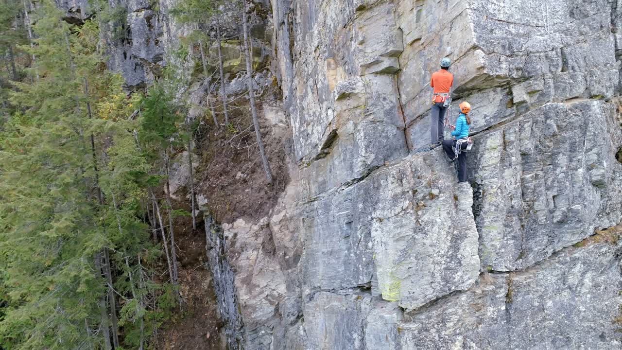 pareja escalando la montaña rocosa 4k