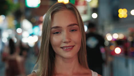 young woman smiling in a night city scene