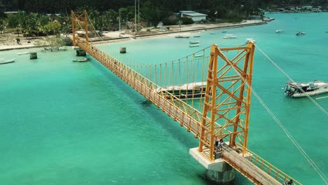 orbiting drone shot of the yellow bridge in nusa lembongan