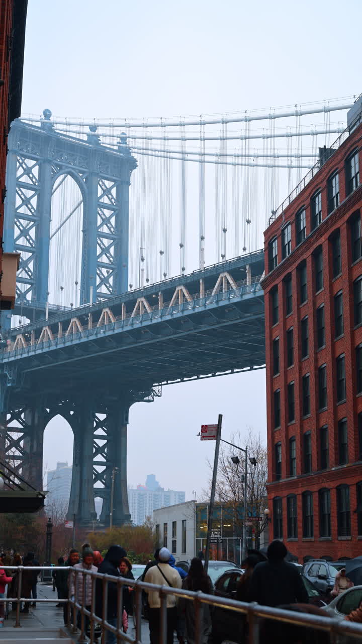 New York, USA, 24 dicembre 2025: vista urbana ravvicinata del Manhattan Bridge. Angolazione inferiore della struttura del Manhattan Bridge tra edifici in mattoni
