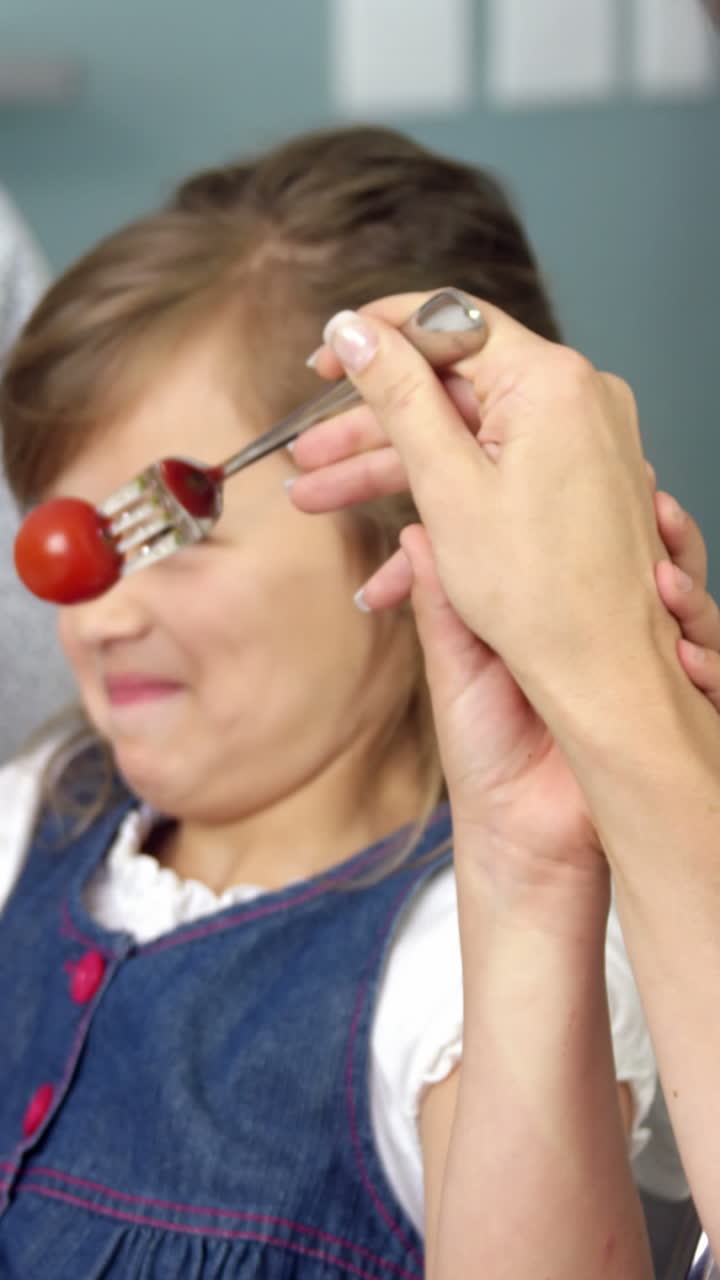 madre y hija felices sentadas a la mesa
