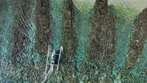 local indonesian fishing boat cruising over the reef and beaching on dry sand