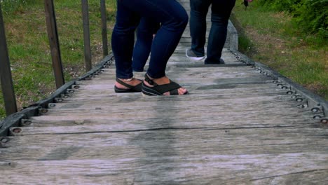 People-walking-down-the-wooden-stairs-while-young-woman-stops-to-wait-with-ring-on-her-finger