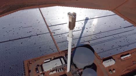 fotografía espectacular de un avión no tripulado de una granja solar térmica con heliostatos que concentran la luz solar en un receptor central, destacando la energía renovable y la generación de energía sostenible