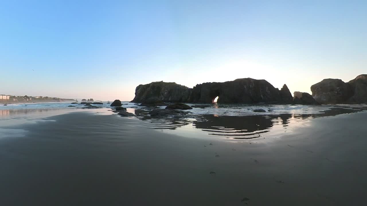 Cameraman filming waves splashing in a sea cave