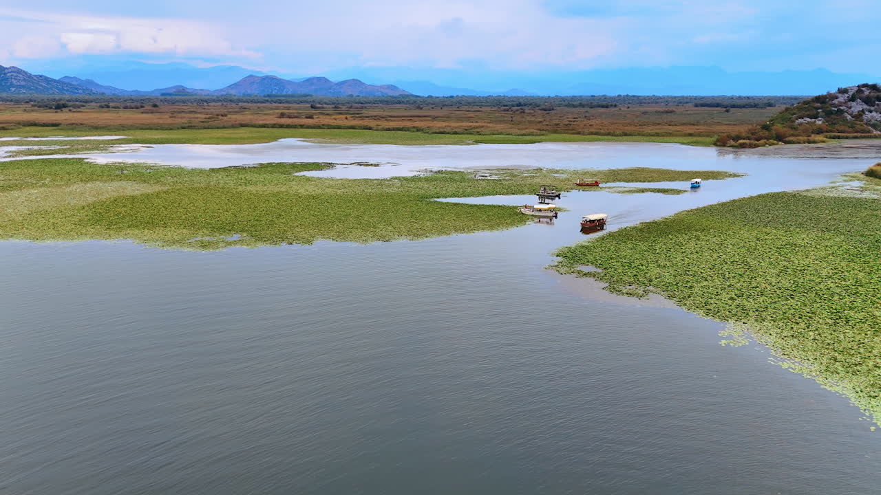 Ulcinj, Montenegro, 14 August 2025: Wide Lake From Above. Aerial view of a wide calm lake with scattered boats and green patches