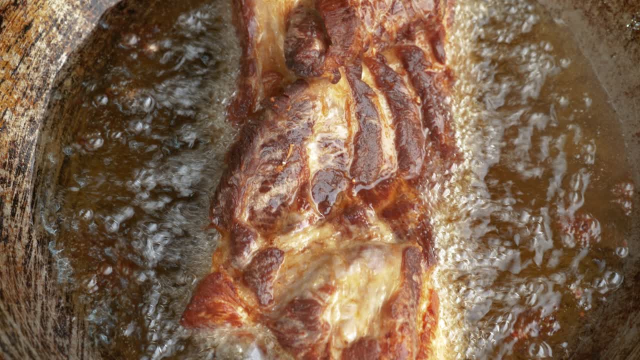 delicioso vientre de cerdo frito en aceite caliente, vista de muñeca de arriba hacia abajo