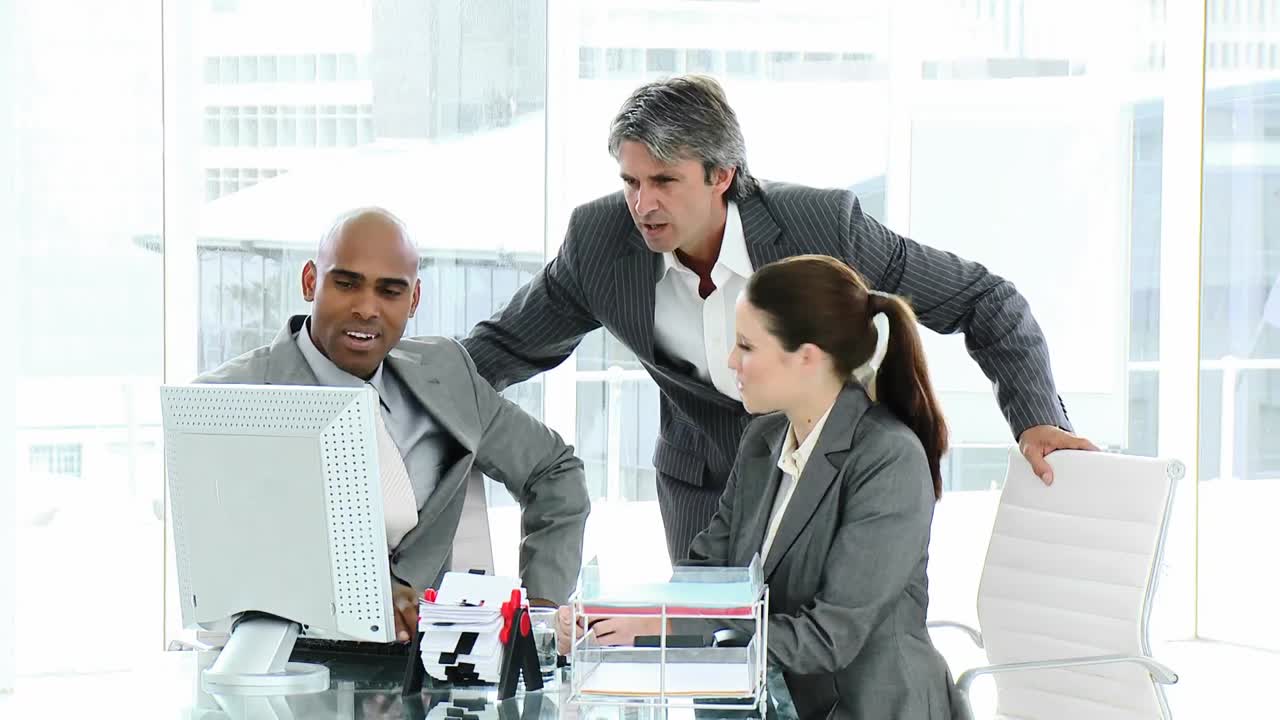 Due professionisti e il loro manager che lavorano al computer
