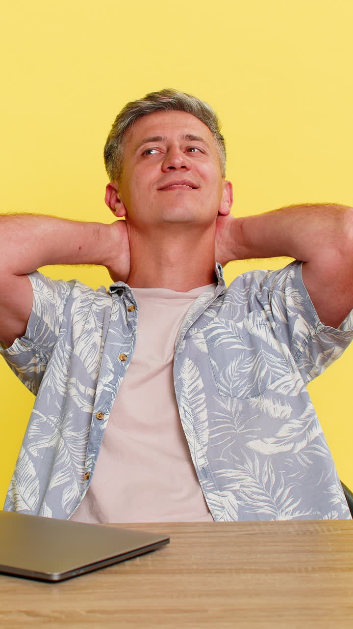 Man working on laptop at desk then relaxing with relief after completing important task or project