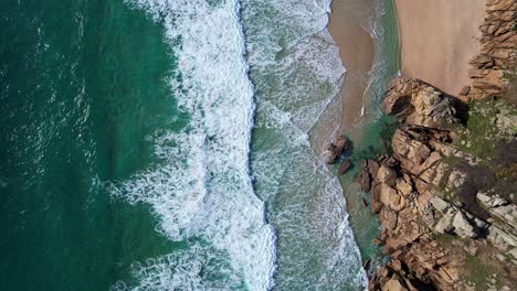 Turquoise-Waves-Top-Down-View-Over-Cornwall-Beach-with-Rocky-Cliffs