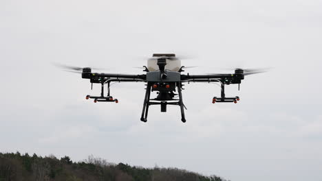 Cerca-De-Agricultura-Drone-Hexacóptero-Flotando-Bajo-El-Cielo,-Cámara-Lenta