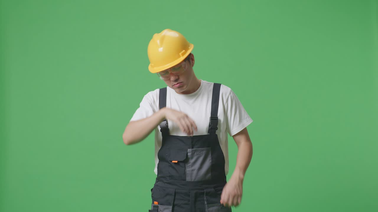 Asian Man Worker Wearing Goggles And Safety Helmet Wiping The Sweat And Being Tired While Standing In The Green Screen Background Studio