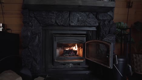 Fuego-Ardiendo-En-Una-Hermosa-Chimenea-Negra-Interior