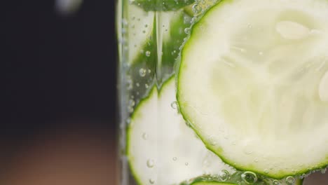 rebanadas redondas de pepino bajo el agua con burbujas de aire.