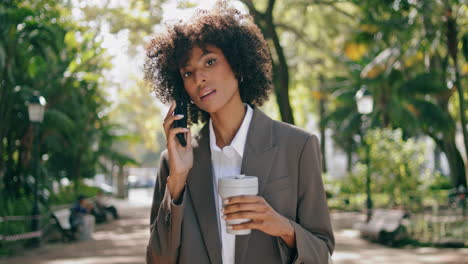 Geschäftsfrau,-Die-Im-Park-Steht-Und-Kaffee-Trinkt,-Nahaufnahme.-Lockiges-Mädchen,-Das-Telefon-Benutzt