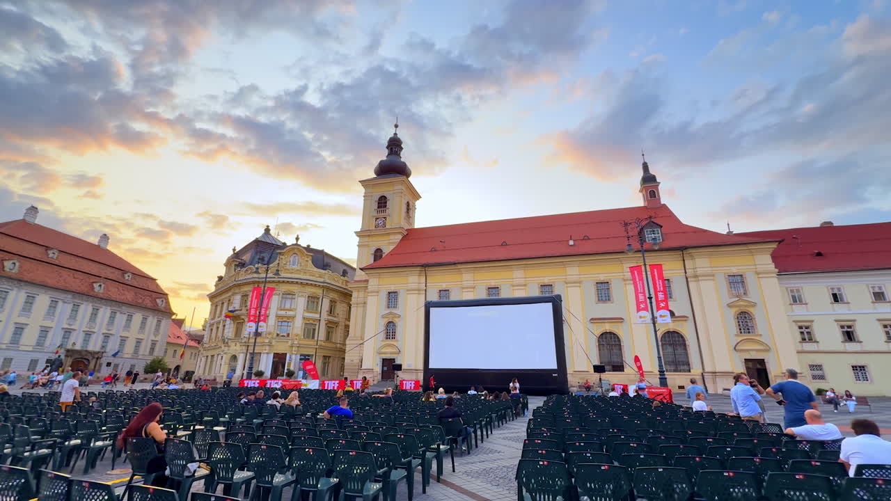 Sibiu, Romania, 17 July 2025: Open-air cinema at sunset in Sibiu. Rows of chairs and a large screen set up in the central square of Sibiu at sunset