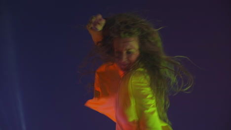 funny unusual woman with long hair having fun smiling dancing in studio against blue background. music dance concept