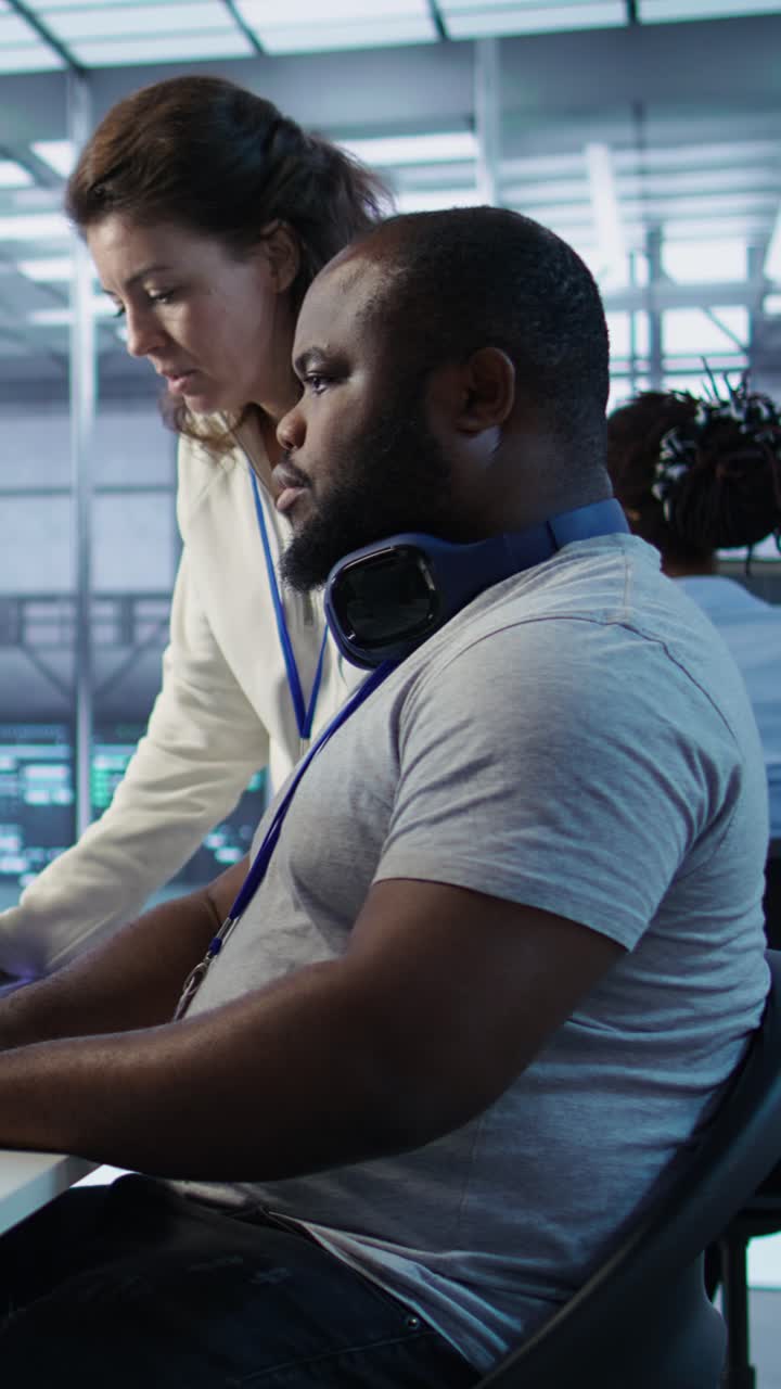 Vertical video Teamworking colleagues updating AI systems on PC and laptop