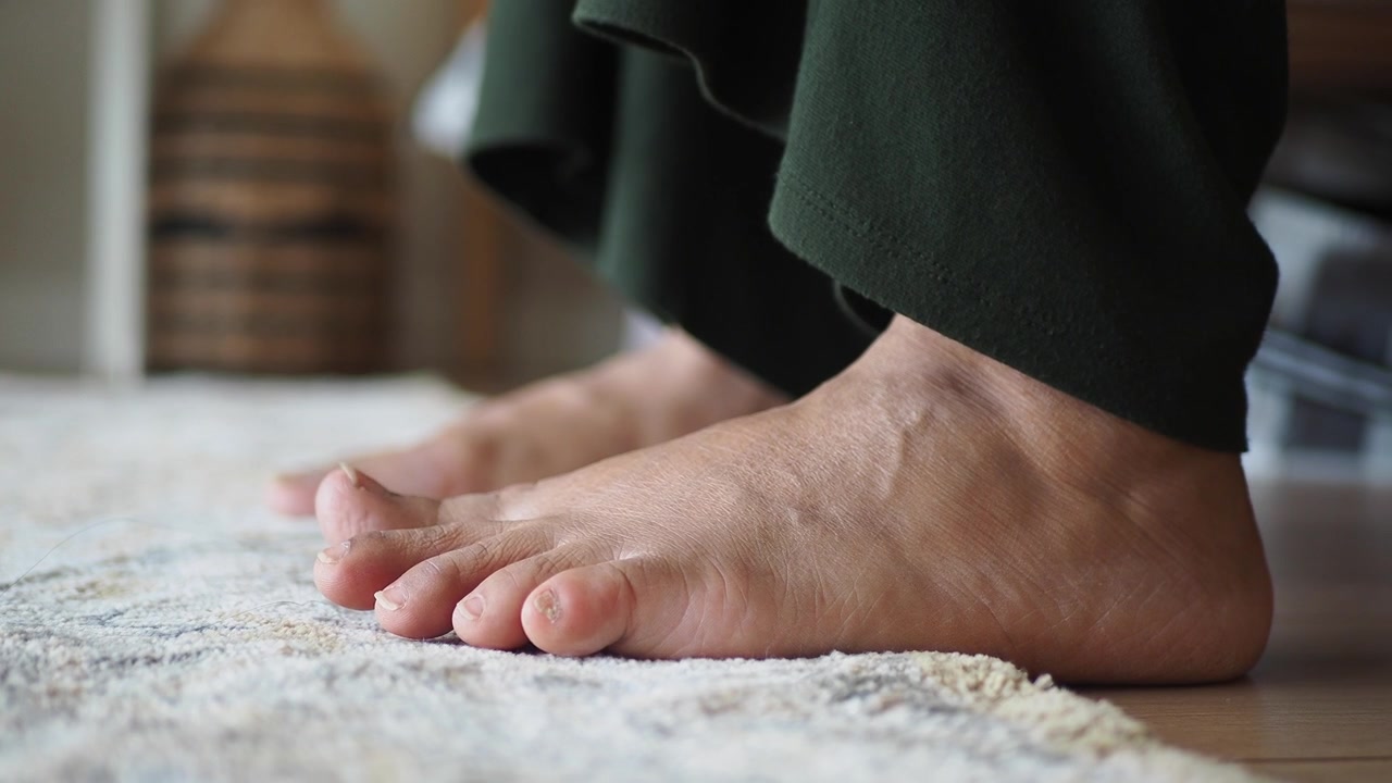 Close-up of Bare Feet Resting on a Rug