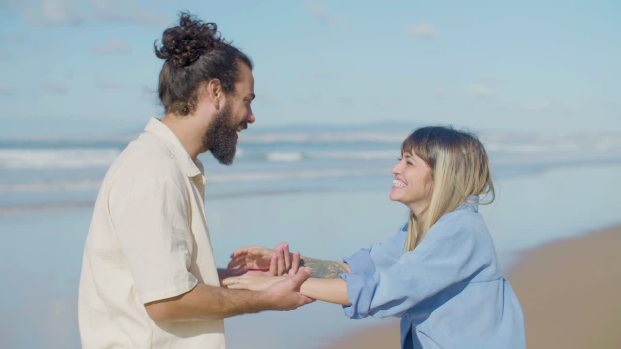 feliz pareja caucásica divirtiéndose en la playa