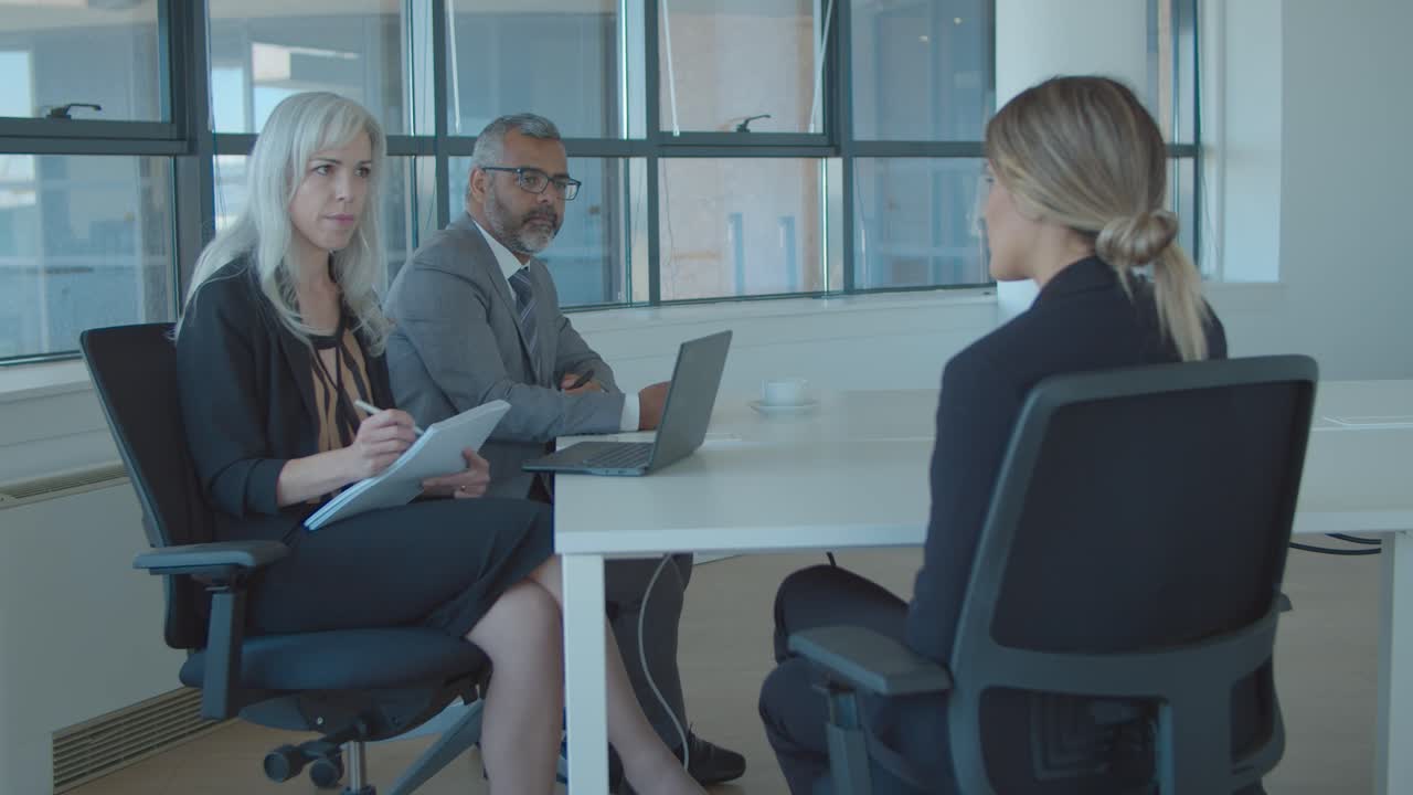 Serious employers meeting and talking to job candidate