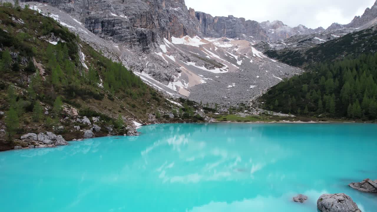 Aerial exploration of Lago di Sorapiss as Dolomiti's turquoise gem, take off shot