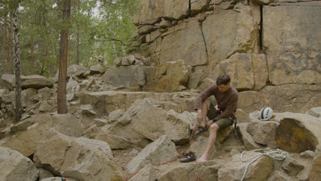 Climber-sitting-at-the-bottom-of-the-cliff