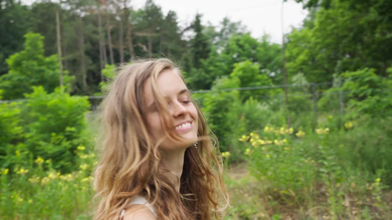 primer plano en cámara lenta de una chica caucásica hippie rubia despeinada feliz caminando en un camping rural en la naturaleza