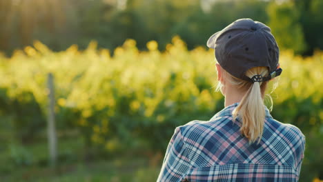 rear view of a woman farmer looking at her garden