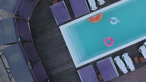 top view of the pool with bright colored inflatable circles. shooting from the drone.