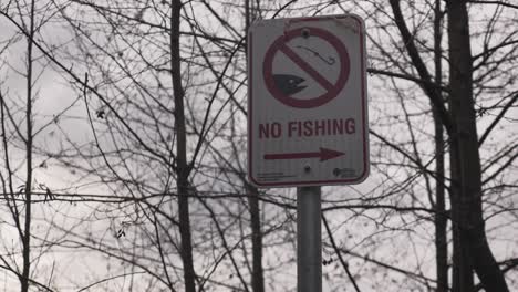 no fishing sign posted at a public park image of hook and fish black and white city governement sign