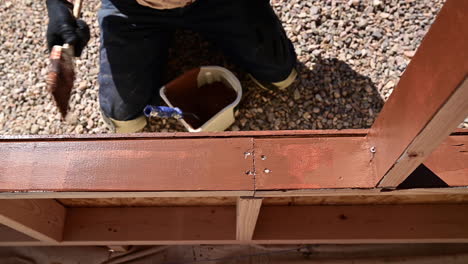 Overhead-Shot-Of-Man-Painting-Patio-Wood---close-up