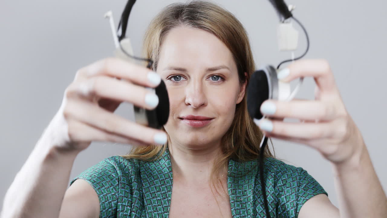 cool female dancer with changing retro headphones to listen to music